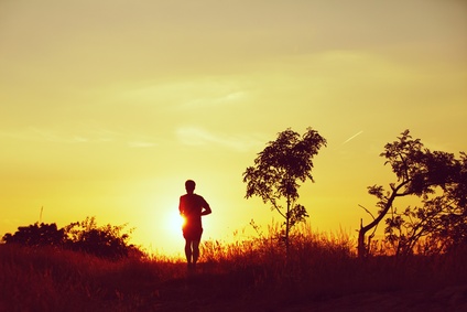 Picture of young man running at the sunset - back lit